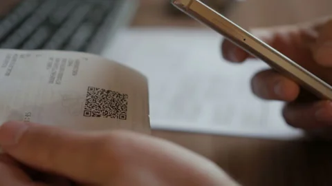 A man scans the QR code on a check from a supermarket. 스톡 동영상 125385916