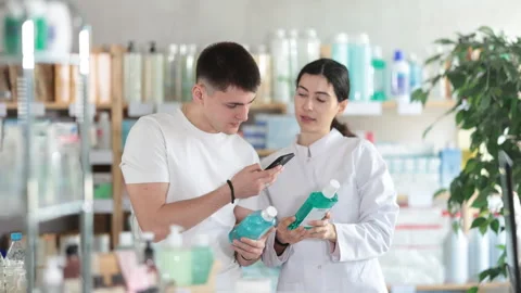 Man scans QR code on mouthwash label. Female pharmacist offers to choose the Stock Footage 311840381