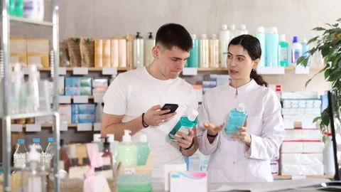 Man scans QR code on mouthwash label. Female pharmacist offers to choose the Stock Footage 323906815
