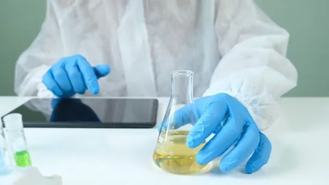 Man scientist is analyzing with a pipette a liquid golden yellow Stock Footage 140515252
