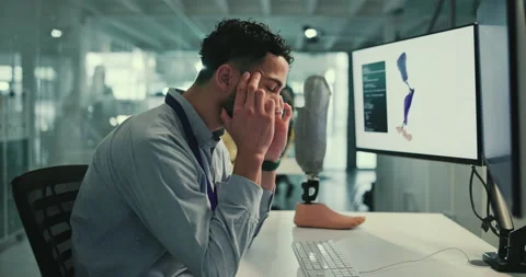 Man, scientist and headache in lab with computer for prosthetic leg design with Stock Footage 283587636