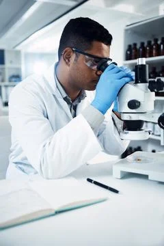 Man, scientist and microscope, analysis in laboratory and check DNA sample with Foto stock