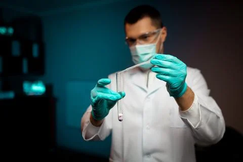 Man scientist or technologist doing experiment in a laboratory pipetting a Foto stock