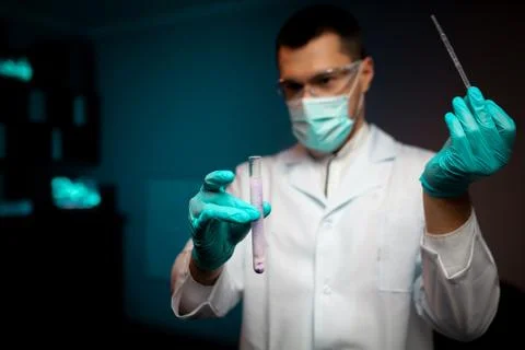 Man scientist or technologist doing experiment in a laboratory pipetting a 写真素材