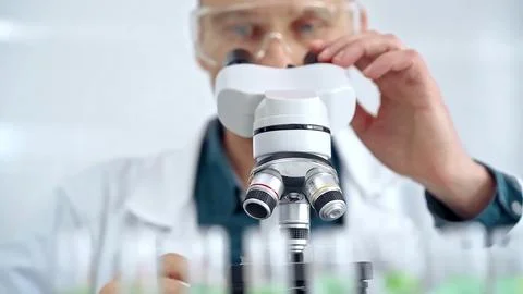 Man scientist with protective glasses using microscope in laboratory 스톡 사진