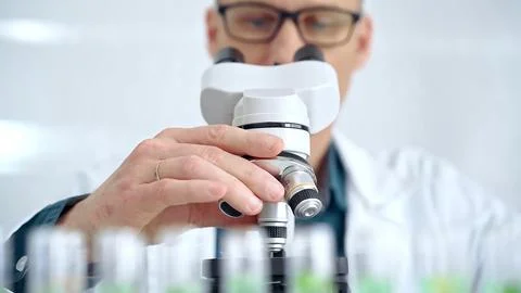Man scientist with protective glasses using microscope in laboratory Stock-Fotos