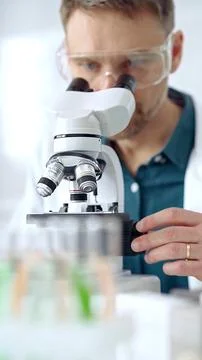 Man scientist with protective glasses using microscope in laboratory Stock-Fotos