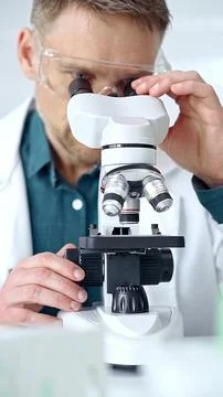 Man scientist with protective glasses using microscope in laboratory 스톡 사진