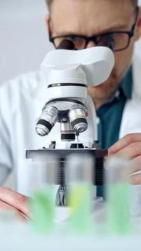 Man scientist using microscope in laboratory. Microbiology science concept Stock Photos