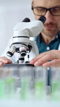 Man scientist using microscope in laboratory. Microbiology science concept Stock Photos