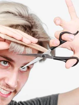 Man with scissors and comb creating new coiffure Stock Photos