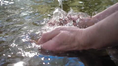 Man scooped up his hands clean water from the river and rises up.Slow mo, slo mo Stock Footage
