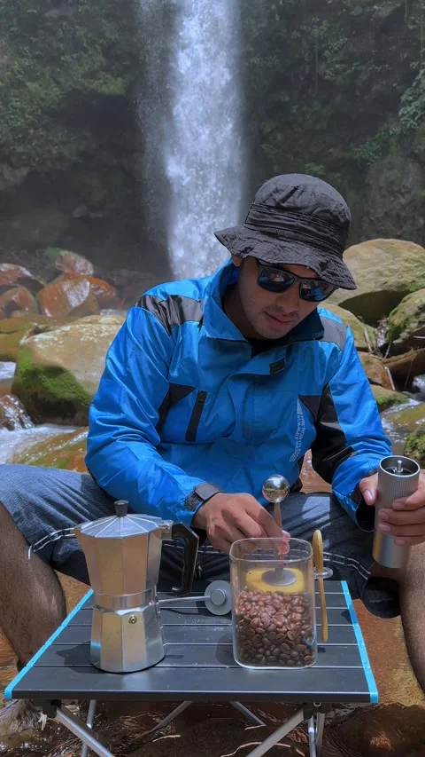 Man Scooping Coffee Beans into Grinder by Waterfall, Vertical Shot Stock Footage 321104817