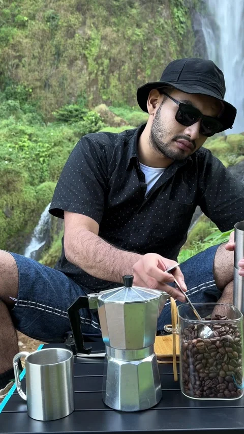 Man Scooping Coffee Beans into Grinder Outdoors by Waterfall Vertical Stock-Footage 323907684