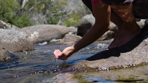 Man scooping water from stream Video stock 73489350