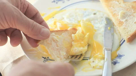 Man scoops up egg with toast piece Stock Footage 55165604