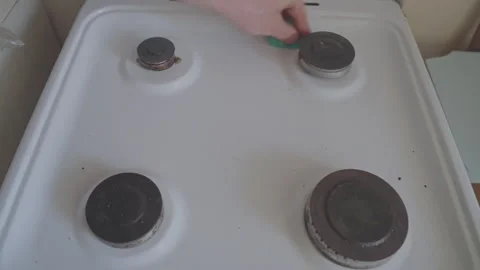 Man with scouring sponge wipes surface of old gas ceramic stove from dirt and Stock Footage 264149255
