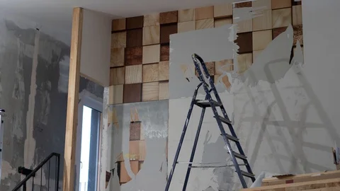 Man in with a scraper in the process of removing old wallpaper. Preparing the Stock Footage 121668506