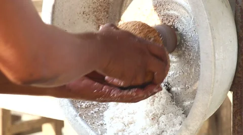Man scrapes a coconut using a machine Stock Footage 44922754