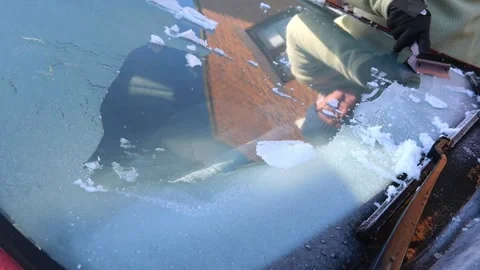 Man scrapes frost off car windshield on cold winter morning Stock Footage 326228776