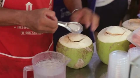 Man Scrapes Young Green Coconut Meat, Pours Water Juice in Container Open Market Stock Footage 228801812