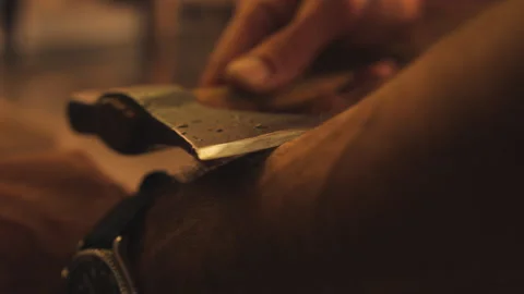 Man scraping axe on forearm Stock Footage 275632224