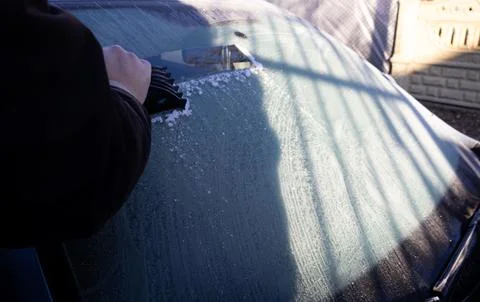 Man scraping ice from the windshield Stock Photos