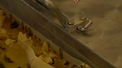 Man scraping wax from his machine   Stock Footage 74057404