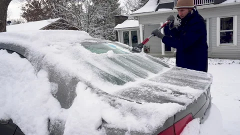 Man Scraps Snow off rear Window of a Grey Car Stock Footage 147632725