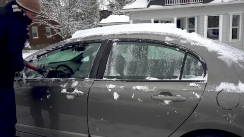 Man Scraps Snow off side Windows of a Grey Car Stock Footage 147677389