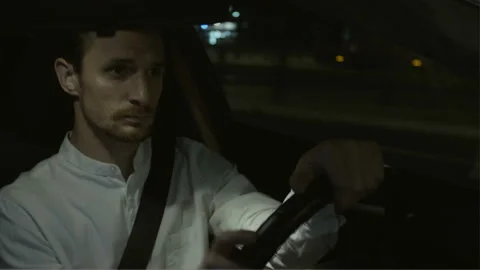 Man Scratching his Cheek and Driving Through a Junction Stock Footage 123170569