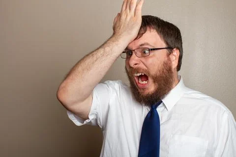 Man screaming in anger while banging his forhead Stock Photos