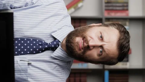 Man is screaming. Vertical view bearded handsome man at workplace screaming 動画素材 133921315