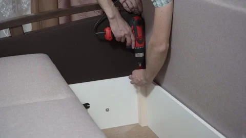 Man with a screwdriver assembles a sofa Video stock 309650170
