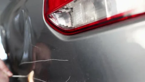 A man with a screwdriver in his hand spoils, scratches someone else's car Stock Footage 227375601