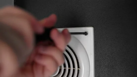 The man is screwing a screw into the ventilation system of the house Stock Footage 153278819