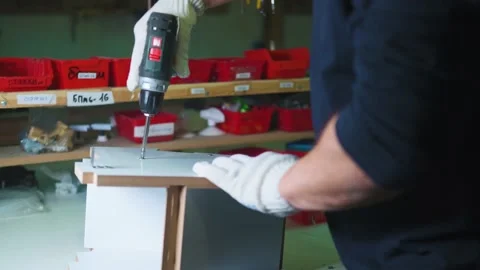 Man screwing a self-tapping screw into a chipboard with a screwdriver close-up Stock Footage 231799623