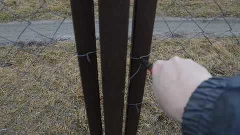 Man screwing the wire on the gate Vídeo Stock 171988217