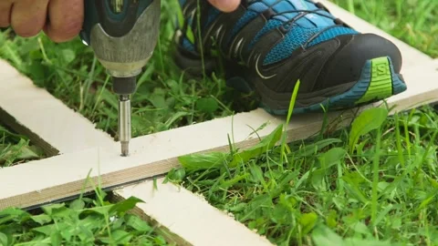 A Man Screws 2 Boards Together with an Electric Screwdriver Stock Footage 257973059