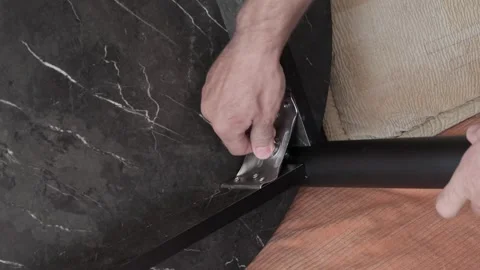 Man screws leg table 스톡 동영상 337661401