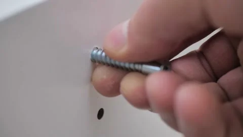 Man screws a self-tapping screw with a screwdriver. Macro shooting. Close-up Stock Footage 221863683