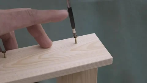 Man screws self-tapping screw into wooden structure Video stock 330429220