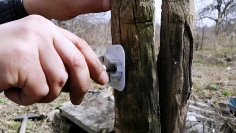 A man screws a socket to a street pole.  Electrician screwing the socket Stock Footage 183355510