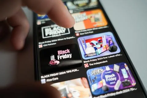 Man scroll on internet shops and looking black friday deals Stock Photos