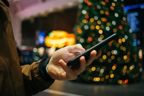 Man scroll through phone at central train station Foto stock