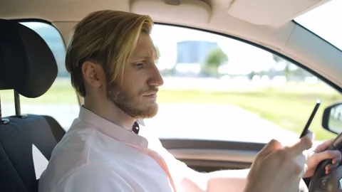 Man scrolling and checking smartphone while in a car and yawns Stock Footage 82826224