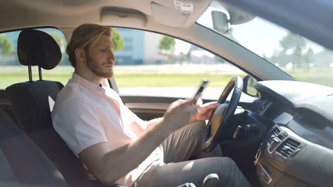 Man scrolling and checking smartphone while in a car and yawns Stock Footage 82826607