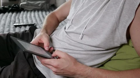 Man Scrolling on Electronic Book Reader While Resting at Home Stock Footage 339216580