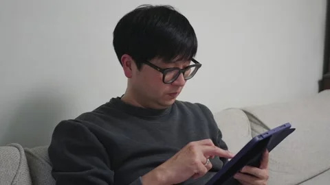 Man scrolling on his ipad Stock Footage 259964501