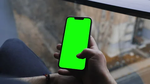 A man scrolling with his thumb on the chroma key screen of a smartphone Video stock 234508643